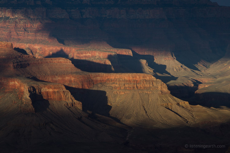 Shafts of late afternoon sunlight illuminate the Grand Canyon